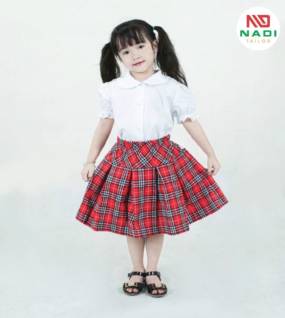 1 cô gái ở độ tuổi hồn nhiên, xinh xắn với thiết kế dễ thương, có áo tay bồng và cổ tròn phù hợp với lứa tuổi Đồng phục nữ tiểu học